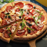 Gourmet pizza topped with thinly sliced prosciutto, fresh rocket, Parmesan and mozzarella