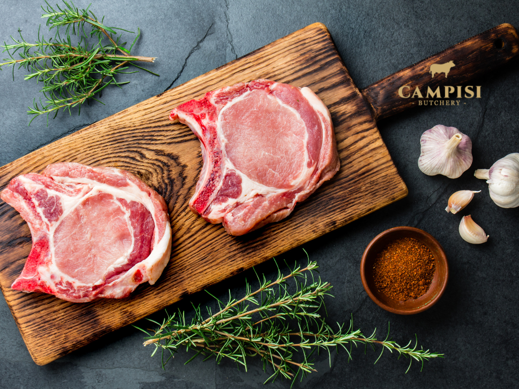 Raw pork shoulder, pork belly and pork loin arranged side by side to show differences in fat content and texture