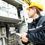Industrial electrician connecting electrical power cables to warehouse machinery