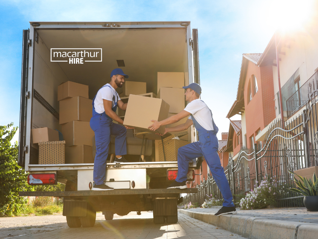 Two-tonne tray truck carrying secured building materials on an open loading tray