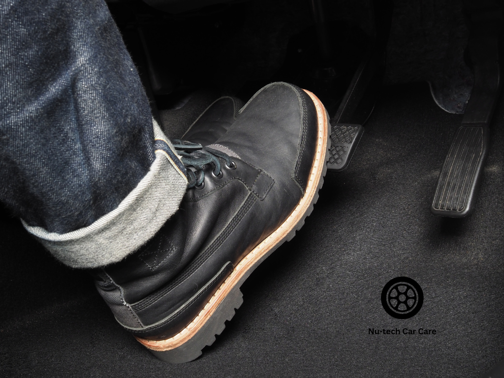 Driver pressing the brake pedal inside a vehicle while seated in the driver's position. Car Care, Car Maintenance, Car Service, car services nearby, mechanics open on sundays, car battery repair near me, cooling system services