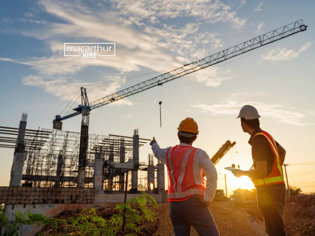 Construction business manager inspecting earthmoving machinery while considering equipment requirements for ongoing projects.