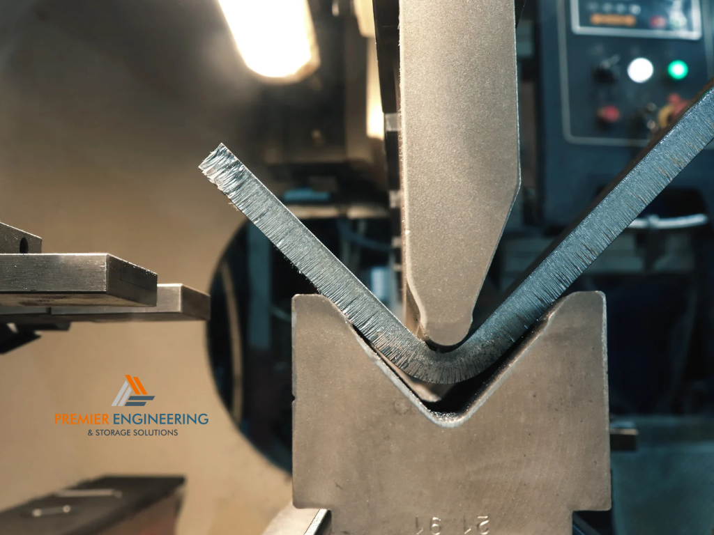 Industrial CNC press brake bending a sheet metal panel into an angled component using forming tools.