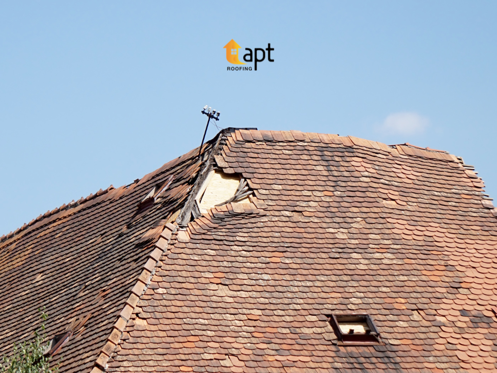Storm-damaged tiled roof showing displaced roof tiles and exposed roofing materials after severe weather. emergency roof repair sydneyroof leak repair cost, tile roof repair sydney, storm damage roof repair, roof repairs sydney, roof refurbishing sydney, emergency ceiling leak repair, metal roof repair cost